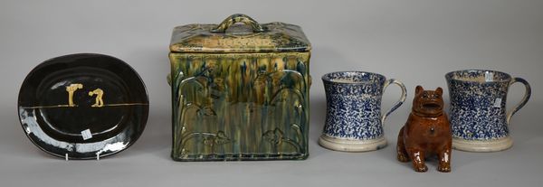 An earthenware bread bin, relief moulded with trailing vines in a mottled green glaze, 30cm wide, a slipware pottery plate initialled 'P.C.', with hum