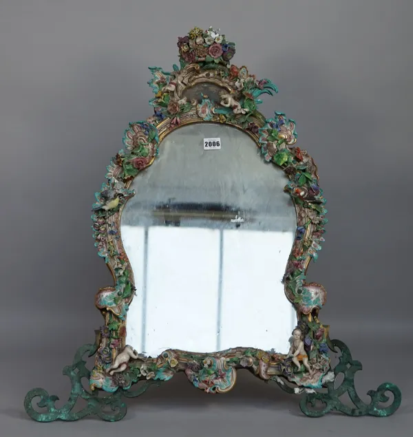 A Meissen porcelain flower encrusted easel mirror, 19th century, of cartouche shape surmounted by a floral bouquet, the scroll moulded frame applied w