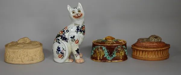 A polychrome painted porcelain game dish with moulded rabbit to lid, a majolica game pie dish and over moulded with game, a caneware game pie dish and