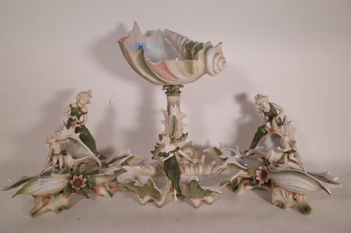 A 20th century three piece ceramic centre piece with cherubs, fairies and conch shell decoration, 38cm high (a.f.) (3).