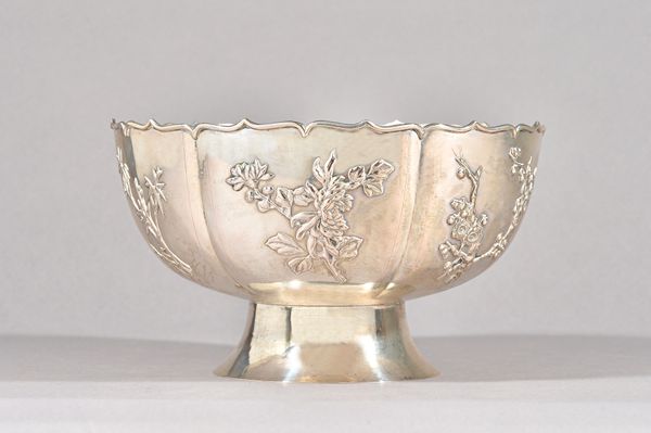 A Chinese bowl, of panelled form, decorated with sprays of differing blossom and bamboo, raised on a swept circular foot, diameter 23cm, weight 755 gm