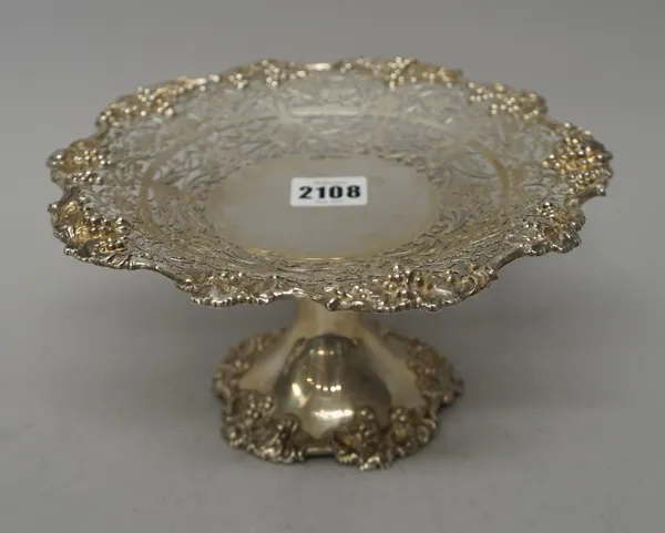 A silver pedestal tazza, of shaped circular form, the wide rim cast, pierced and engraved with a border of fruiting vine, raised on a trumpet shaped f