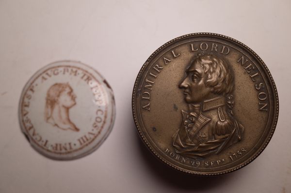 A 19th century gilt brass snuff box of circular form, made to commemorate the Death of lord Nielson, 6cm wide and a concave enamel box lid with Roman