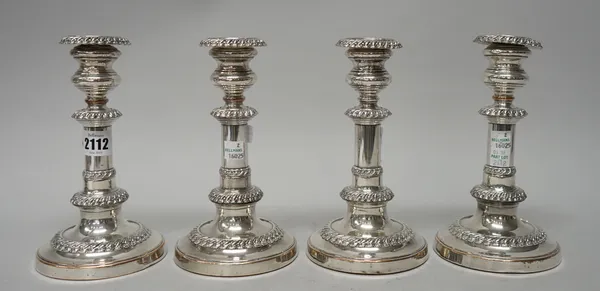 A set of four Sheffield plated telescopic action table candlesticks, each decorated with gadrooned rims with detachable sconces, raised on circular ba