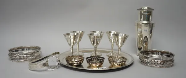 A Mappin & Webb plated cocktail set, comprising; a circular tray, a cocktail shaker and a set of six stemmed cups, in an Art Deco design and further p
