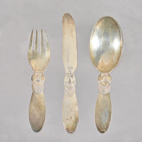 A Georg Jensen silver Cactus pattern three piece christening set, comprising; a knife, a fork and a spoon, import mark London 1935, with the retailer'