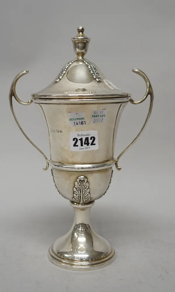 A silver twin handled trophy cup and cover, presentation inscribed, the detachable cover with an urn finial, raised on a circular foot, Birmingham 192