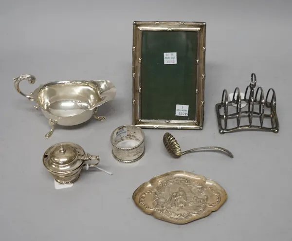 Silver and silver mounted wares, comprising; a shaped oval trinket dish, a sauceboat, a napkin ring, a mustard pot, a sugar sifting spoon, a toastrack