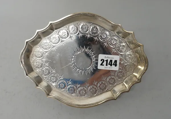 A George III silver teapot stand, of shaped oval form, with bright cut engraved decoration, raised on four tapered feet, length 18.7cm, London 1791, w