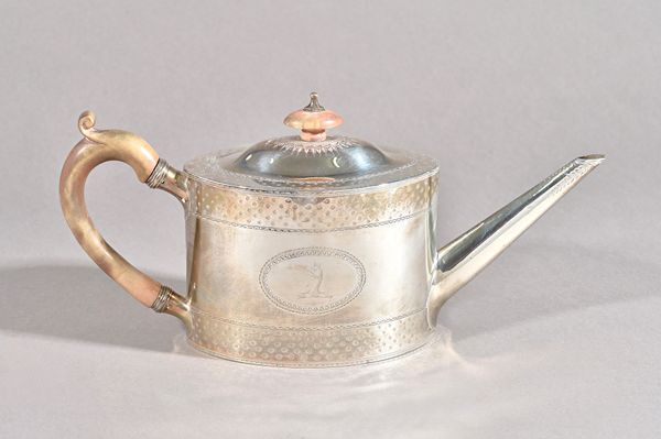 A George III silver teapot, of oval form, crest engraved within a bright cut surround and with decorated bands to the borders, with wooden fittings, L