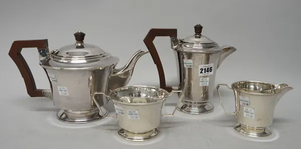 A silver four piece tea set, comprising; a teapot, a hot water jug, a twin handled sugar bowl and a milk jug, the two larger pieces with composition f