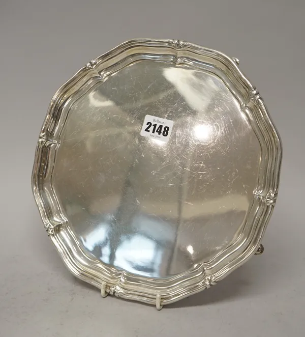 A silver salver of shaped circular form, with a raised rim, on four pad feet, Sheffield 1942, diameter 25.5cm, weight 724 gms.