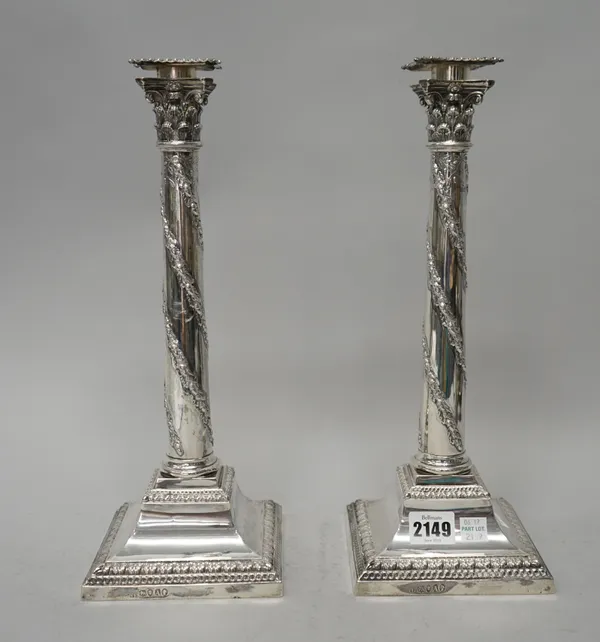 A pair of Victorian table candlesticks, each with a tapered stem, decorated with an acorn and oak leaf spiral band, raised on a swept square base, dec