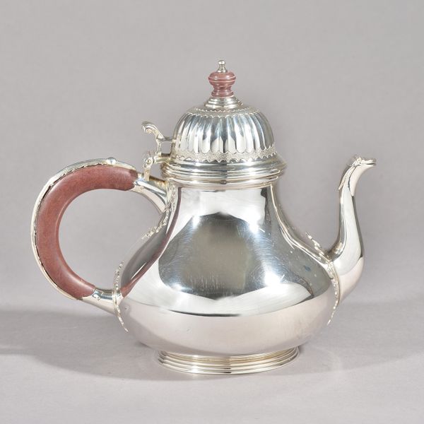 A Tiffany & Co England silver teapot, of baluster form, the hinged domed cover with partly fluted decoration, the spout having a hinged cover and with