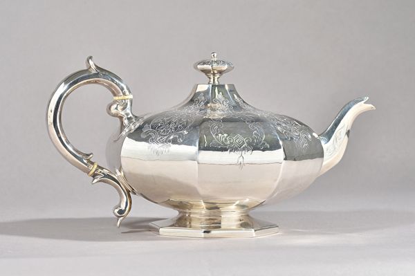 A Victorian silver teapot, of squat octagonal form, with scroll and foliate engraved decoration to the body, raised on an octagonal foot, London 1846,