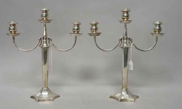 A pair of three light table candelabra, each with a curved arm, raised on a tapered hexagonal stem and on a swept hexafoil base, detailed 900, probabl