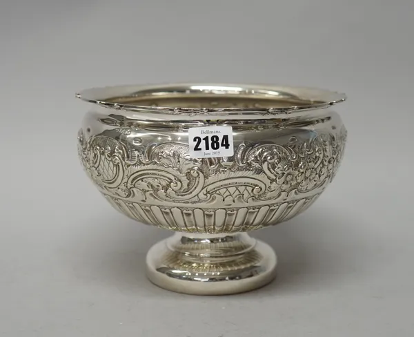 A late Victorian silver bowl, of circular form, the body embossed with a wide floral, foliate and scrolling band above semi-fluted decoration, on a ci