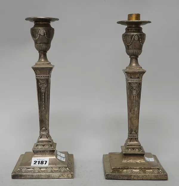 Two similar Victorian silver table candlesticks, each with a tapered stem, raised on a square base, converted for use as table lamps and drilled, one