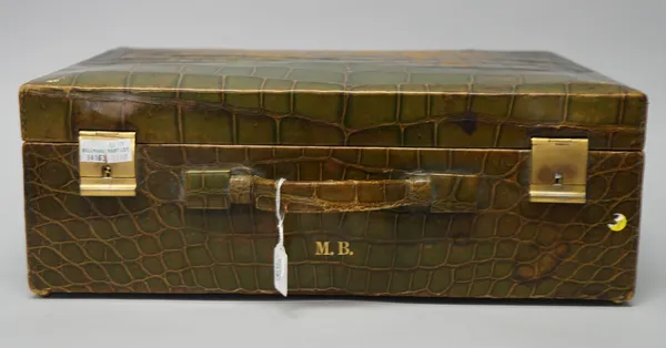 A lady's green stained leather travelling dressing set, fitted with eleven silver mounted brushes, bottles and jars, with reeded decoration, in the Ar