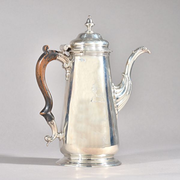 A George II silver coffee pot, of tapered cylindrical form, with an inverted urn shaped finial to the hinged lid, foliate capped spout and raised on a