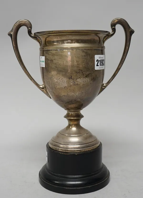 A silver twin handled trophy cup, raised on a circular foot, presentation inscribed, Sheffield 1932, weight 337 gms, with an ebonised stand.