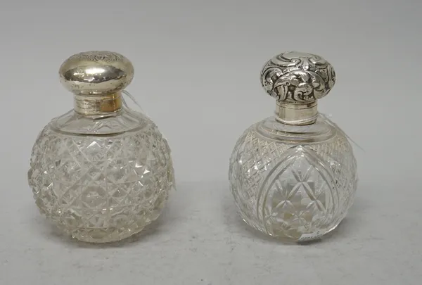 Two silver hinge lidded faceted glass globular scent bottles, of differing designs, Birmingham 1901 and Birmingham 1904, (2).