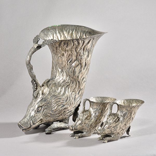 A set of three Italian silver-plated boar form rhytons, retailed by Christian Dior, tallest 27cms high, smaller pair 9.5cms high. (3)  illustrated