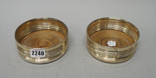 A pair of George III silver wine coasters, Solomon Hougham, London 1799, each with circular ribbed wood base engraved with initials, 12cms diam. (2)