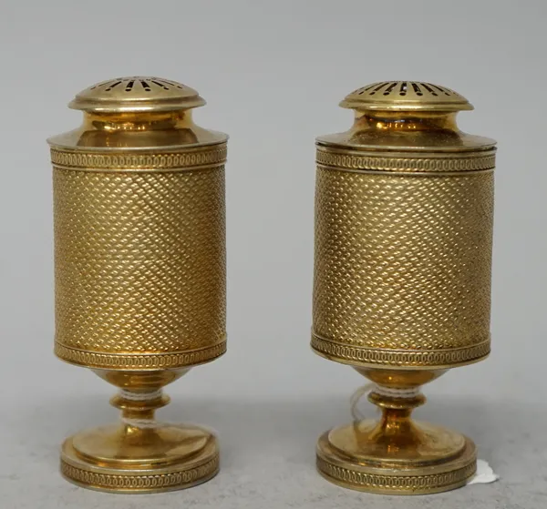 A pair of George III silver pepperettes, John Emes, London, 1805, one engraved with a crest 9.5cms high 200g. (2)