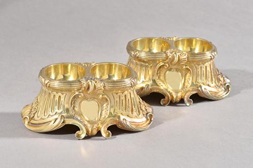 A pair of late 19th century French silver gilt double salt cellars, A. Aucoc, Paris, each with double well set in a scrolling tapering frame, 12.cms w