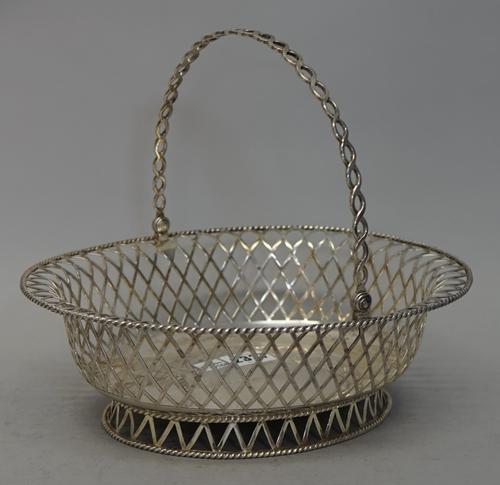 A George V silver swing handled fruit basket, with pierced lattice work decoration and gadrooned borders, London 1910, by C.S. Harris & Sons, weight 7