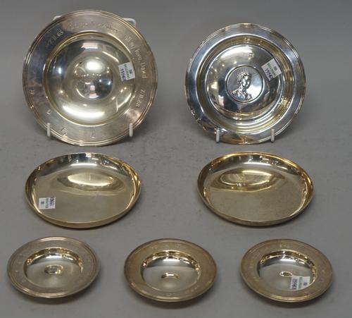 Silver, comprising; a pair of circular plain dishes, London 1963, a circular dish, the centre inset with a coin with an Elizabeth II portrait bust, a