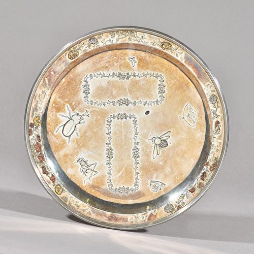 A Victorian silver and mixed-metal circular dish, the border with applied foliate and floral decoration, and the centre engraved and inlaid with insec