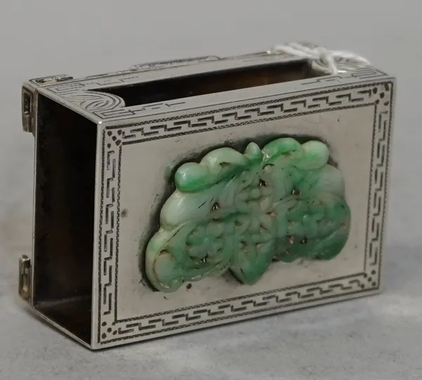 A silver matchbook slide, of rectangular form, the cover applied with a jadeite plaque, otherwise with engraved decoration, raised on four bracket fee
