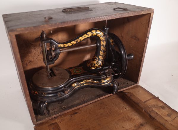 A Jones serpentine sewing machine within a stained pine case.