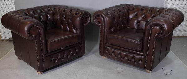 A pair of 20th century brown leather upholstered Chesterfield style armchairs, on bun feet 110cm wide x 73cm high, (2).   B65