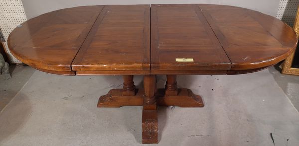 A 20th century oak circular extending dining table, on four turned supports and 'X' frame stretcher, to include two extra leaves 120cm wide x 76cm hig