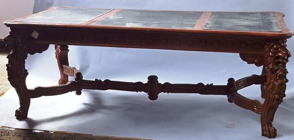 A 17th century style stained beech bureau plat, on four heraldic carved lion supports united by carved X frame stretcher, 216cm long x 116cm wide x 83