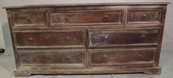 A 20th century Indian hardwood low chest, with three short and four long drawers on bracket feet, 153cm long x 75cm high.