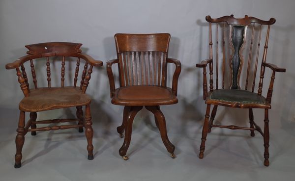 A late 19th century oak captains chair on turned supports, an early 20th century oak open armchair on swivel base and a late Victorian mahogany stick