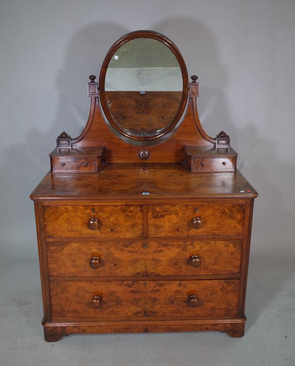 A Victorian walnut dressing chest with three long graduated drawers and oval mirrored back, 107cm wide x 155cm high.