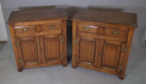 A pair of 20th century oak side cabinets, with two drawers over cupboard base, 81cm wide x 85cm high, (2).