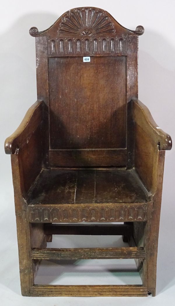 An 18th century oak lambing chair with shell carved back, lacking two drawers to base.