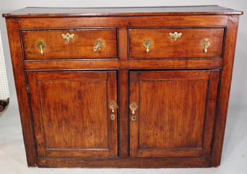A 19th century oak dresser base with two drawers over cupboard base, 136cm wide x 104cm high.
