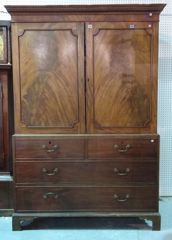 A George III mahogany linen press, the pair of panelled doors over two short and two long graduated drawers on bracket feet, 132cm wide x 193cm high.