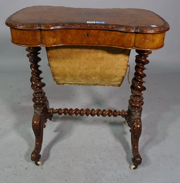 A Victorian figured walnut lift top work table on barley-twist supports, 67cm wide x 72cm high.