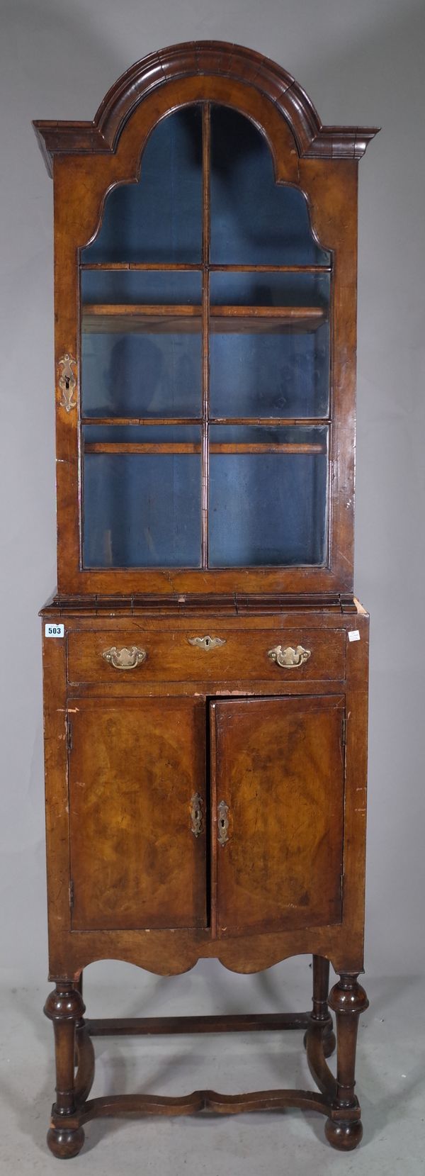 A Queen Anne mahogany arch top display cabinet with single drawer over cupboard doors on bun feet, 56cm wide x 198cm high.