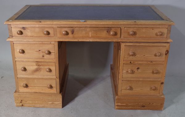 A 20th century pine pedestal desk with blue leather inset top, 132cm wide x 74cm high.