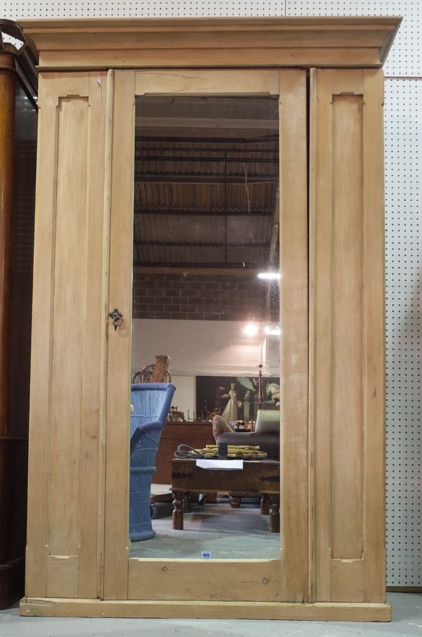 An early 20th century pine double wardrobe with mirrored central door on plinth base, 131cm wide x 200cm high.