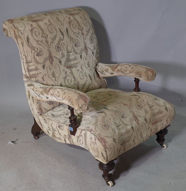 A Victorian mahogany framed low open armchair on ring turned tapering supports.